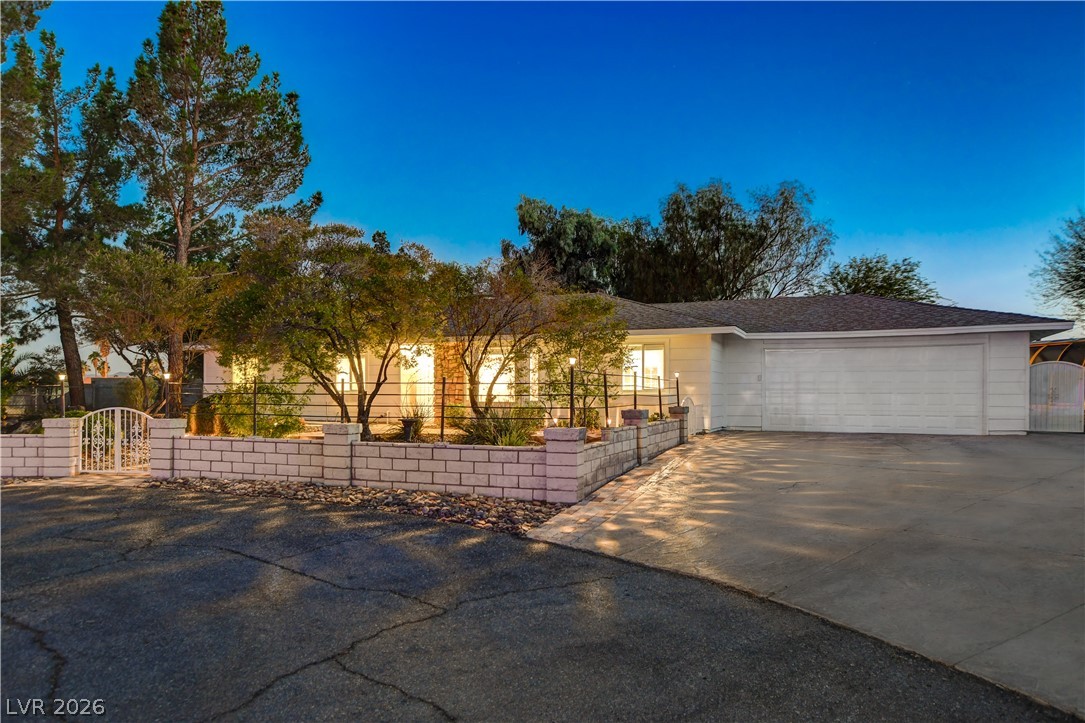 7631 Bermuda Road Las Vegas, NV 89123 - Photo 55 of 64 An inviting exterior with soft illumination, mature landscaping, and a secure gated entry.