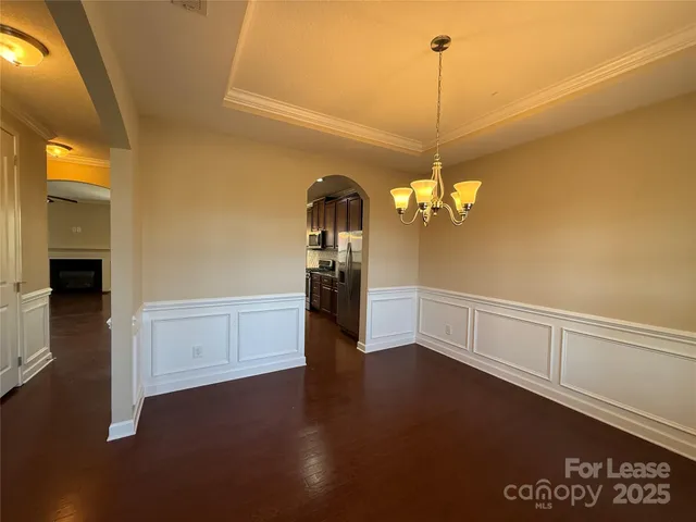 a large kitchen with stainless steel appliances granite countertop wooden cabinets a stove a sink a granite counter tops and a wooden floors