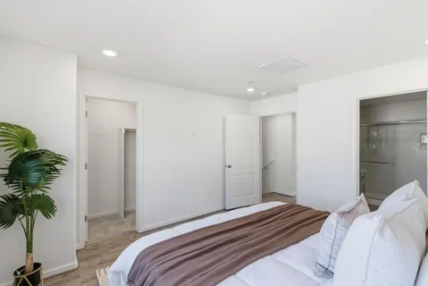 a bedroom with a bed and a potted plant