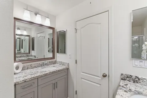 a bathroom with a granite countertop sink and a mirror