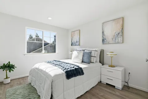 a bedroom with a bed and a painting on the wall