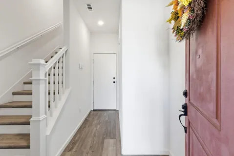 a view of a hallway with wooden floor and staircase