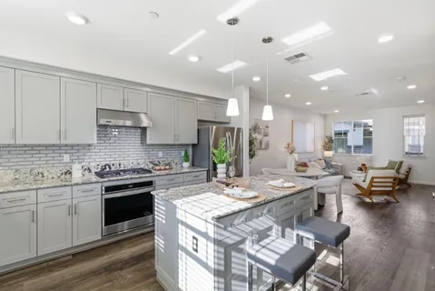 a large kitchen with kitchen island a sink a stove a dining table and chairs