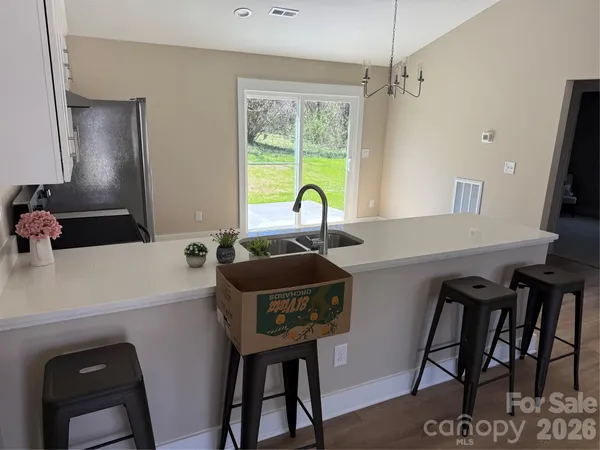 a kitchen with a table chairs sink and wooden floor