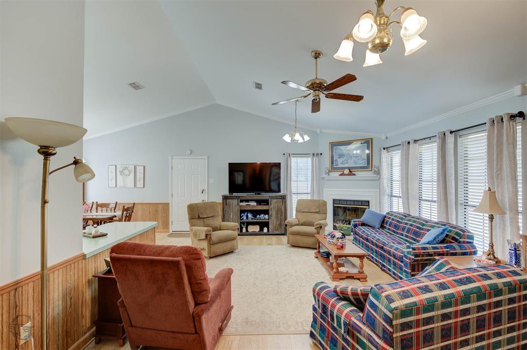 8835 Sebastian Road Keithville, LA 71047 - Photo 13 of 21 Vaulted ceiling, ceiling fan, fireplace with mantel, multiple windows, and wood-finish flooring