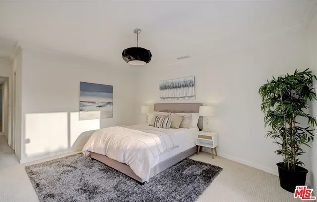 a bedroom with a bed and a potted plant