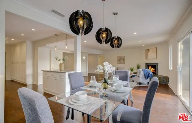 a dining room with furniture a kitchen and chandelier