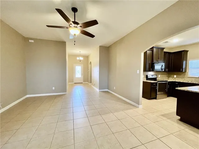an empty room with a ceiling fan and a bathroom