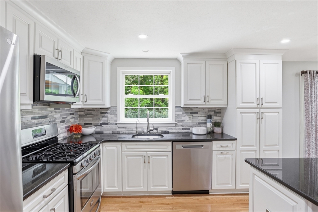 33 Simon Willard Road Acton, MA 01720 - Photo 8 of 42 a kitchen with stainless steel appliances granite countertop a sink stove cabinets and a window