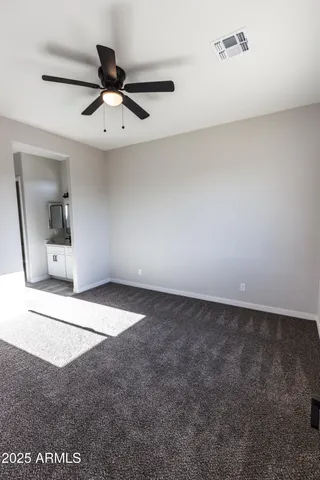 an empty room with a ceiling fan and a window
