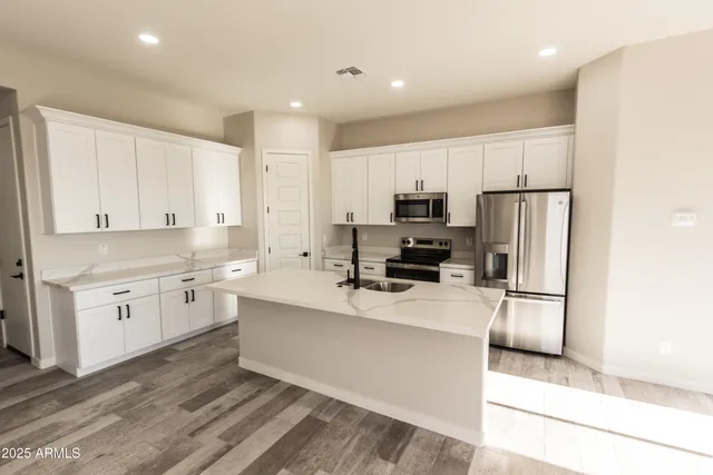 a kitchen with a sink a counter top space stainless steel appliances and cabinets