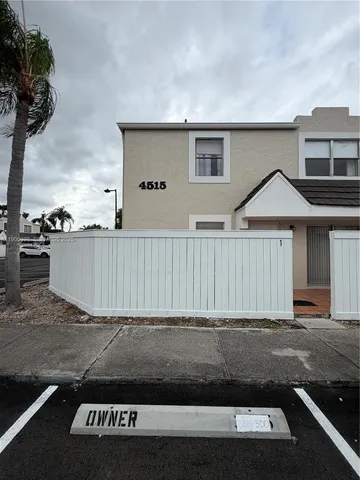 a view of a house with a wooden fence