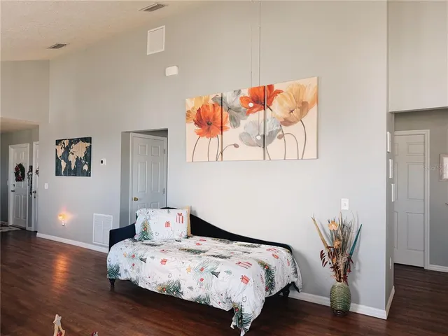 a bedroom with bed and wooden floor