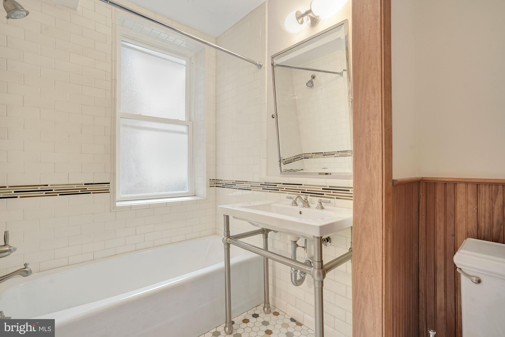 2721 2721-upper Ontario Road Northwest Washington, DC 20009 - Photo 30 of 31 a bathroom with a shower sink and mirror