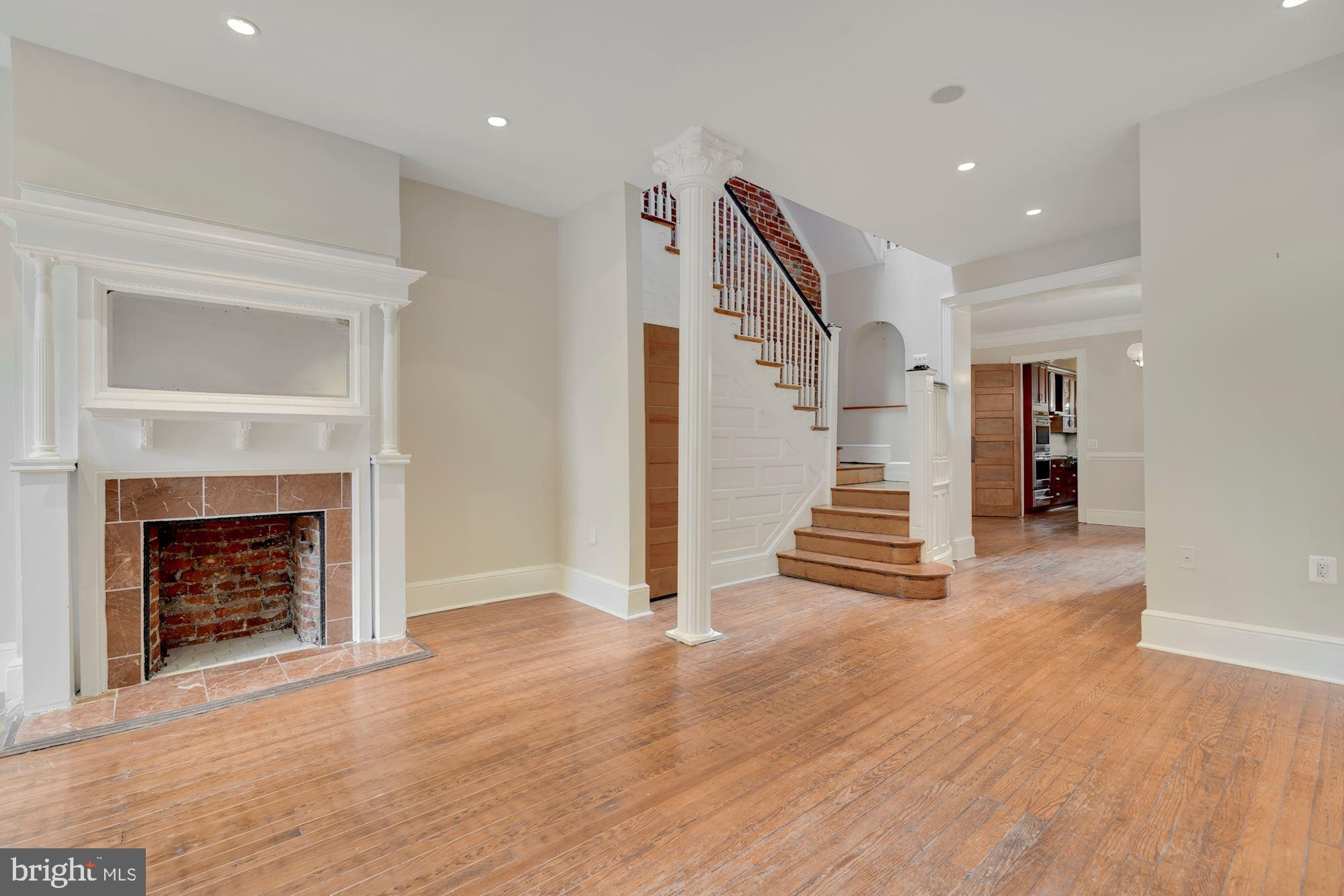 2721 2721-upper Ontario Road Northwest Washington, DC 20009 - Photo 5 of 31 a view of a livingroom with a fireplace stairs and windows