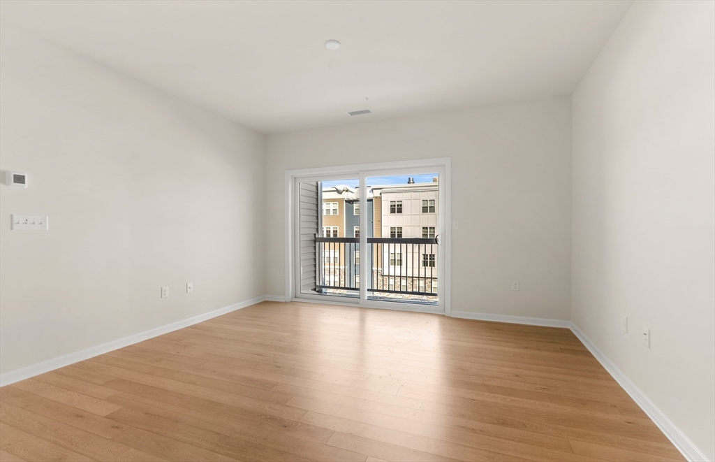 6 Stratton Drive, Unit 303 Woburn, MA 01801 - Photo 13 of 29 a view of an empty room with wooden floor and a window