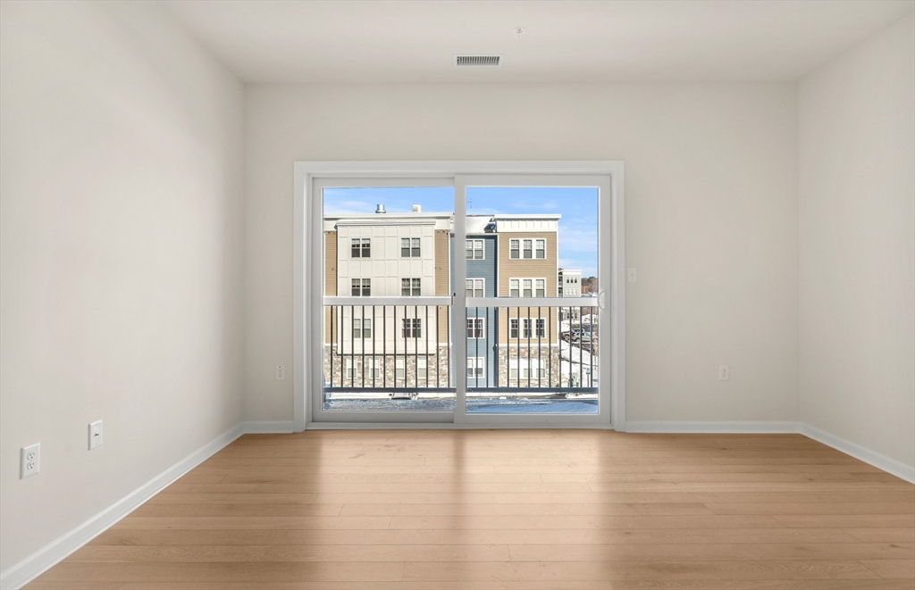 6 Stratton Drive, Unit 303 Woburn, MA 01801 - Photo 16 of 29 an empty room with wooden floor and windows