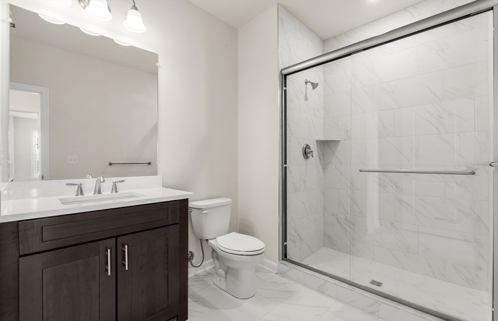 6 Stratton Drive, Unit 303 Woburn, MA 01801 - Photo 24 of 29 a bathroom with a granite countertop sink toilet and shower
