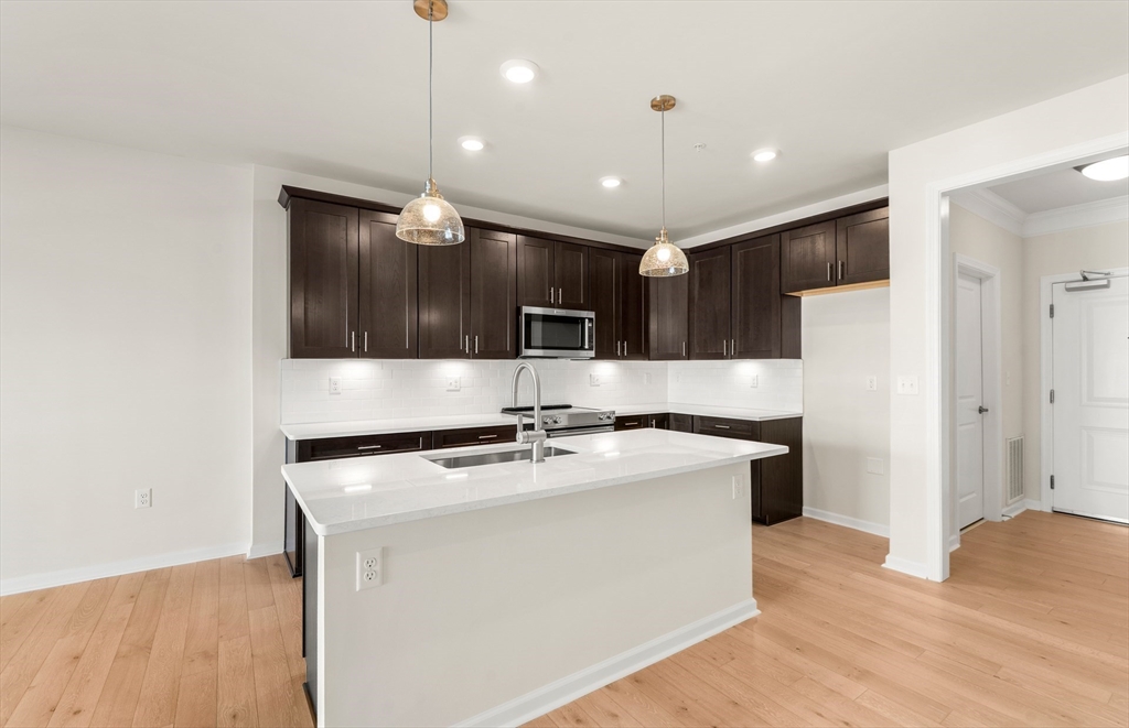 6 Stratton Drive, Unit 303 Woburn, MA 01801 - Photo 5 of 29 a kitchen with stainless steel appliances granite countertop a sink a stove a refrigerator and a microwave