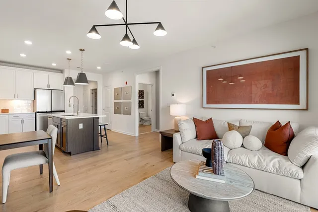 a living room with furniture and kitchen view