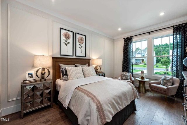 a bedroom with a bed and large windows