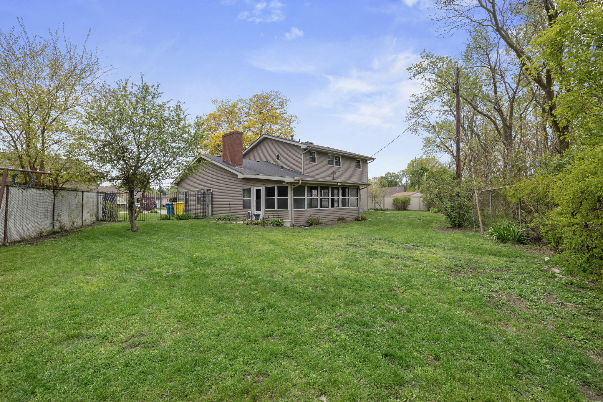 218 West 38th Court Griffith, IN 46319 - Photo 22 of 23 a view of house with a big yard and large trees