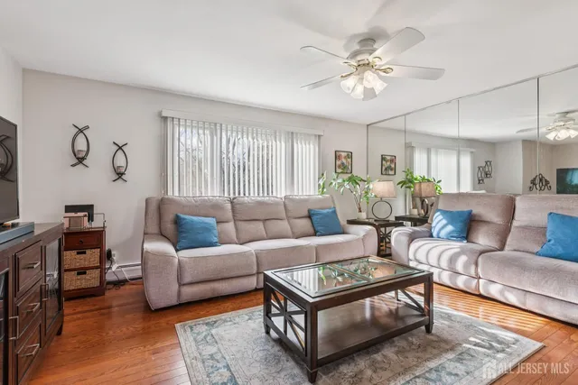 a living room with furniture a large window and a rug