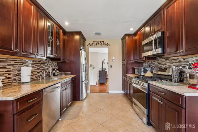 a kitchen with stainless steel appliances granite countertop a stove refrigerator sink and cabinets