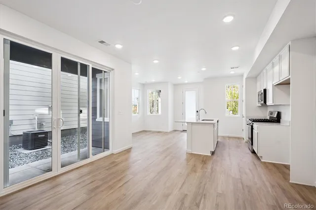 a view of a kitchen with furniture and wooden floor