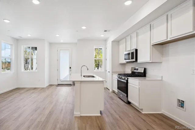 a kitchen with cabinets wooden floor and a fireplace