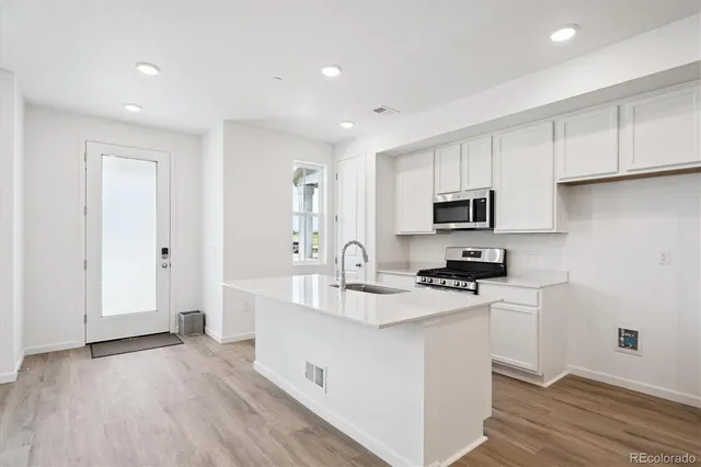 a kitchen with white cabinets and sink