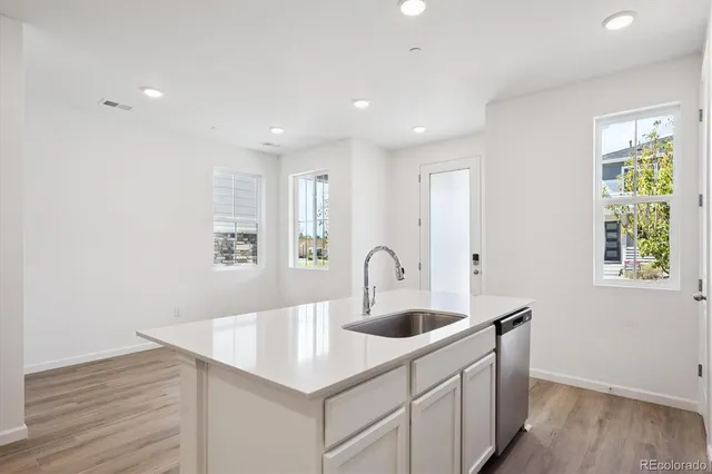 a kitchen with kitchen island a sink and wooden floors