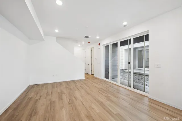 a view of an empty room with wooden floor