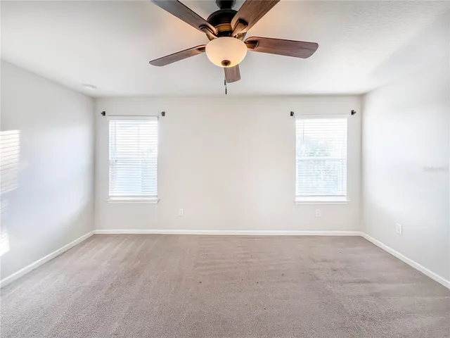 an empty room with a window and a fan