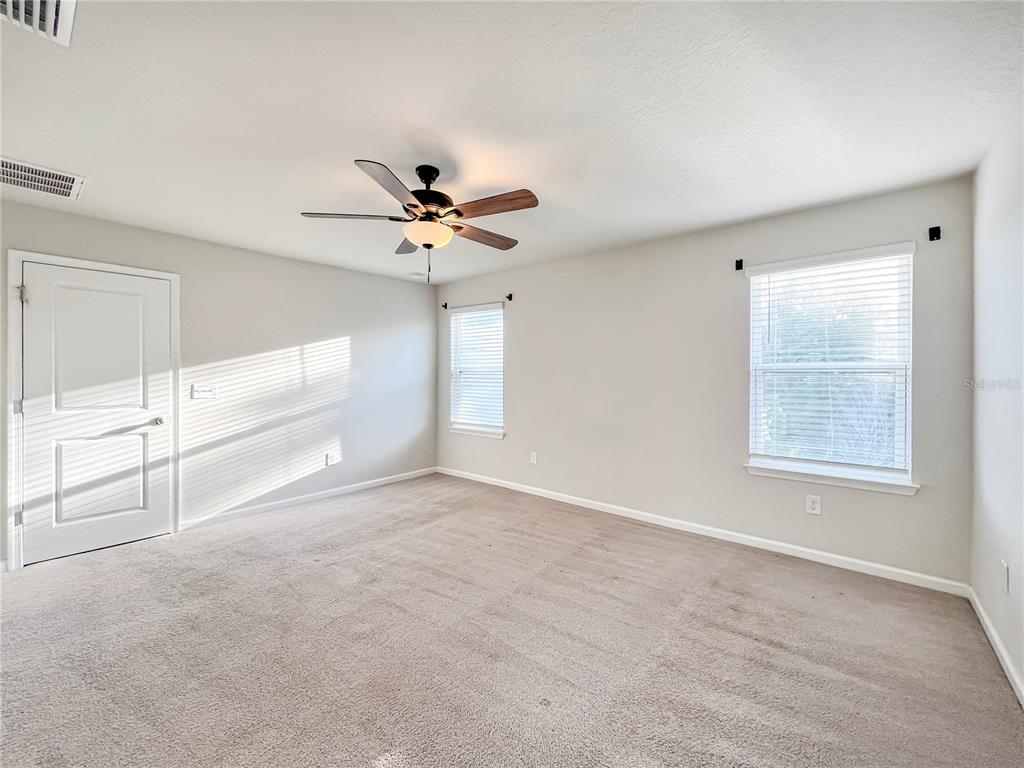 8511 Rain Lily Crossing Parrish, FL 34219 - Photo 21 of 34 an empty room with windows and fan