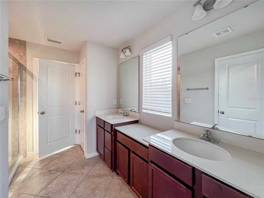 8511 Rain Lily Crossing Parrish, FL 34219 - Photo 23 of 34 a bathroom with a granite countertop sink and a mirror