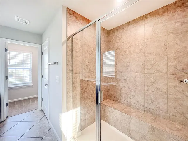 a bathroom with a shower and a glass door