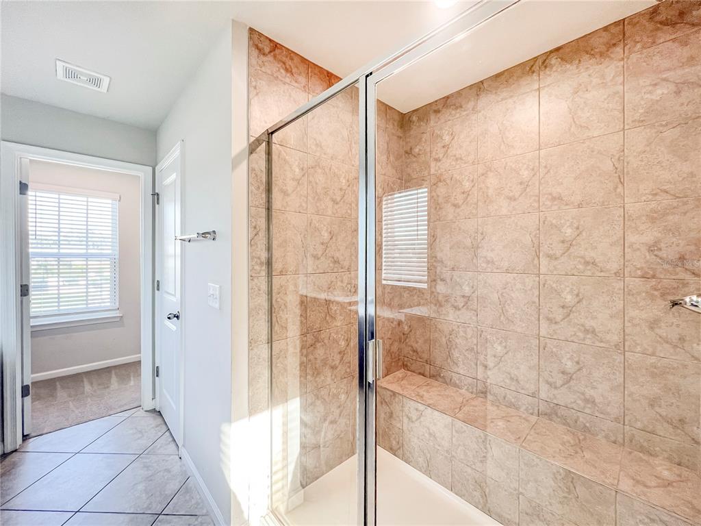 8511 Rain Lily Crossing Parrish, FL 34219 - Photo 24 of 34 a bathroom with a shower and a glass door