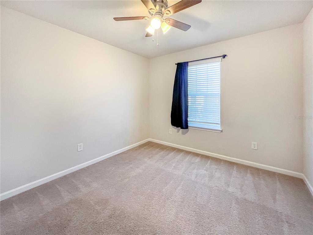 8511 Rain Lily Crossing Parrish, FL 34219 - Photo 26 of 34 an empty room with a window and a ceiling fan
