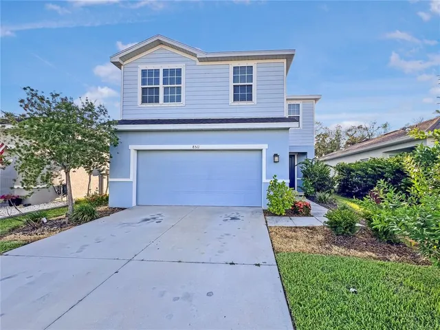 a front view of a house with a yard and garage