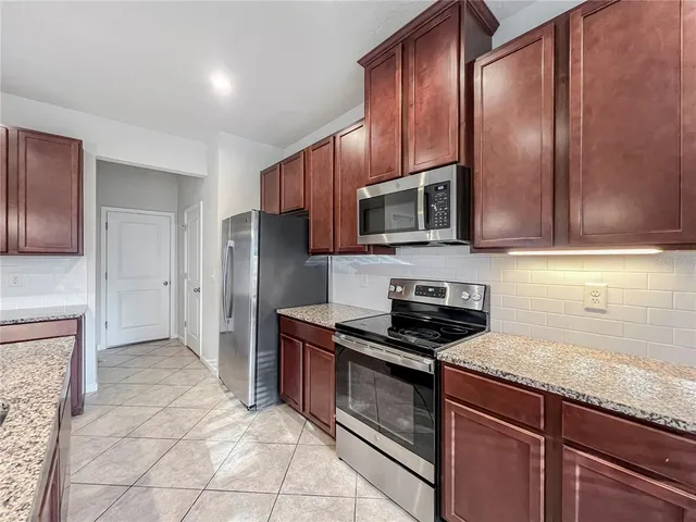 a kitchen with granite countertop wooden cabinets stainless steel appliances and a granite counter tops