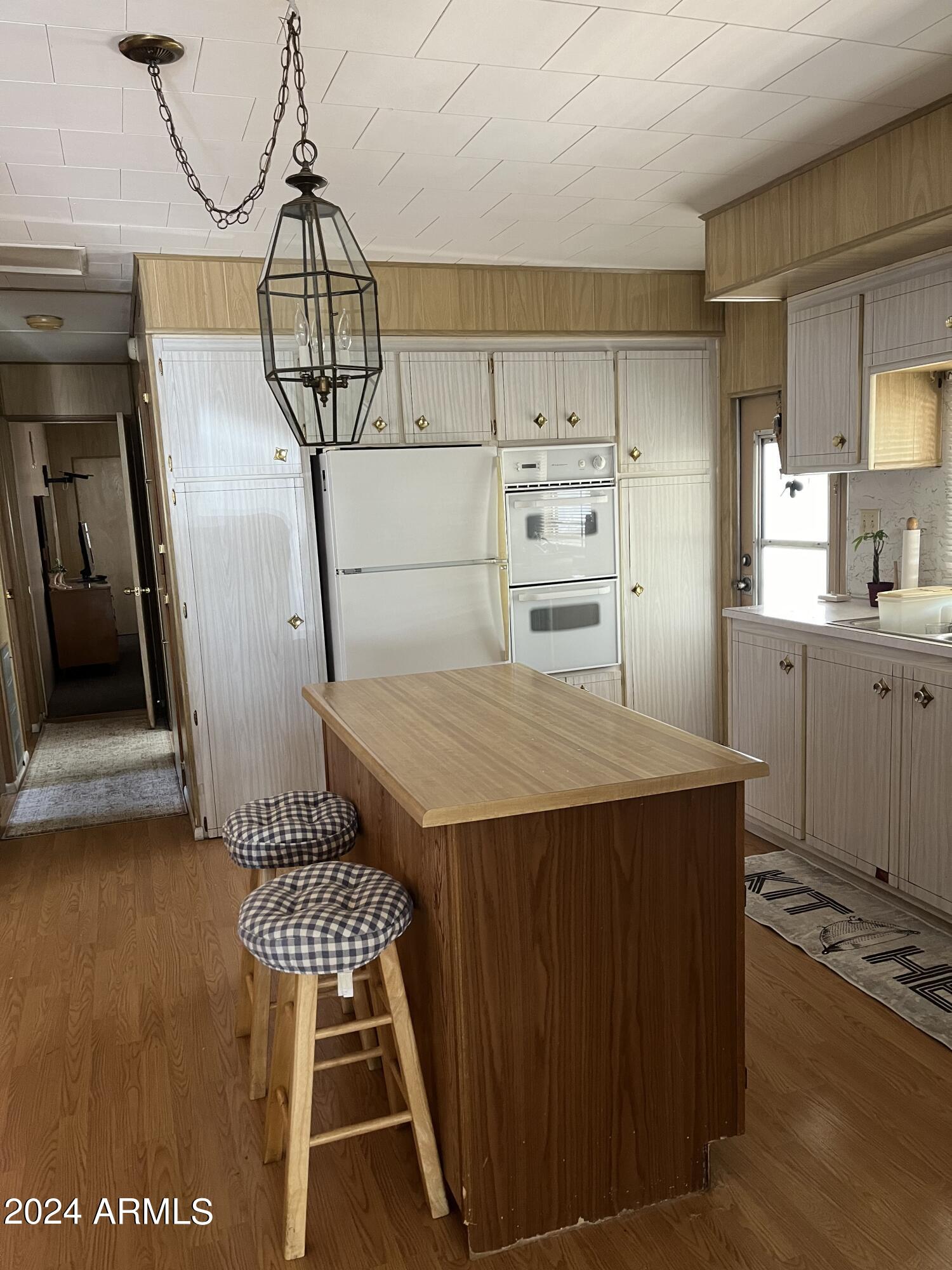 2460 East Main Street, Unit F2 Mesa, AZ 85213 - Photo 3 of 17 a kitchen with kitchen island a stove a counter space a sink and cabinets