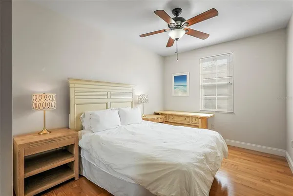 a bedroom with a bed and a ceiling fan
