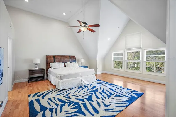 a bedroom with a bed and a table with wooden floor