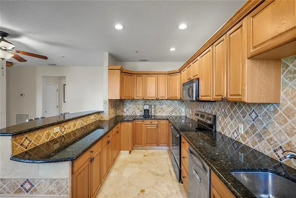 a kitchen with granite countertop a sink a stove and cabinets