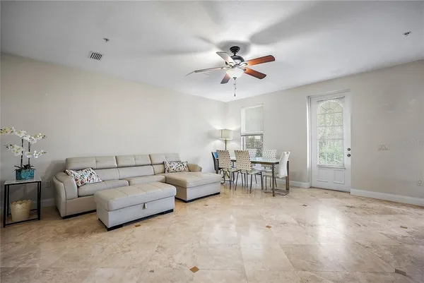a living room with furniture white walls and chandelier