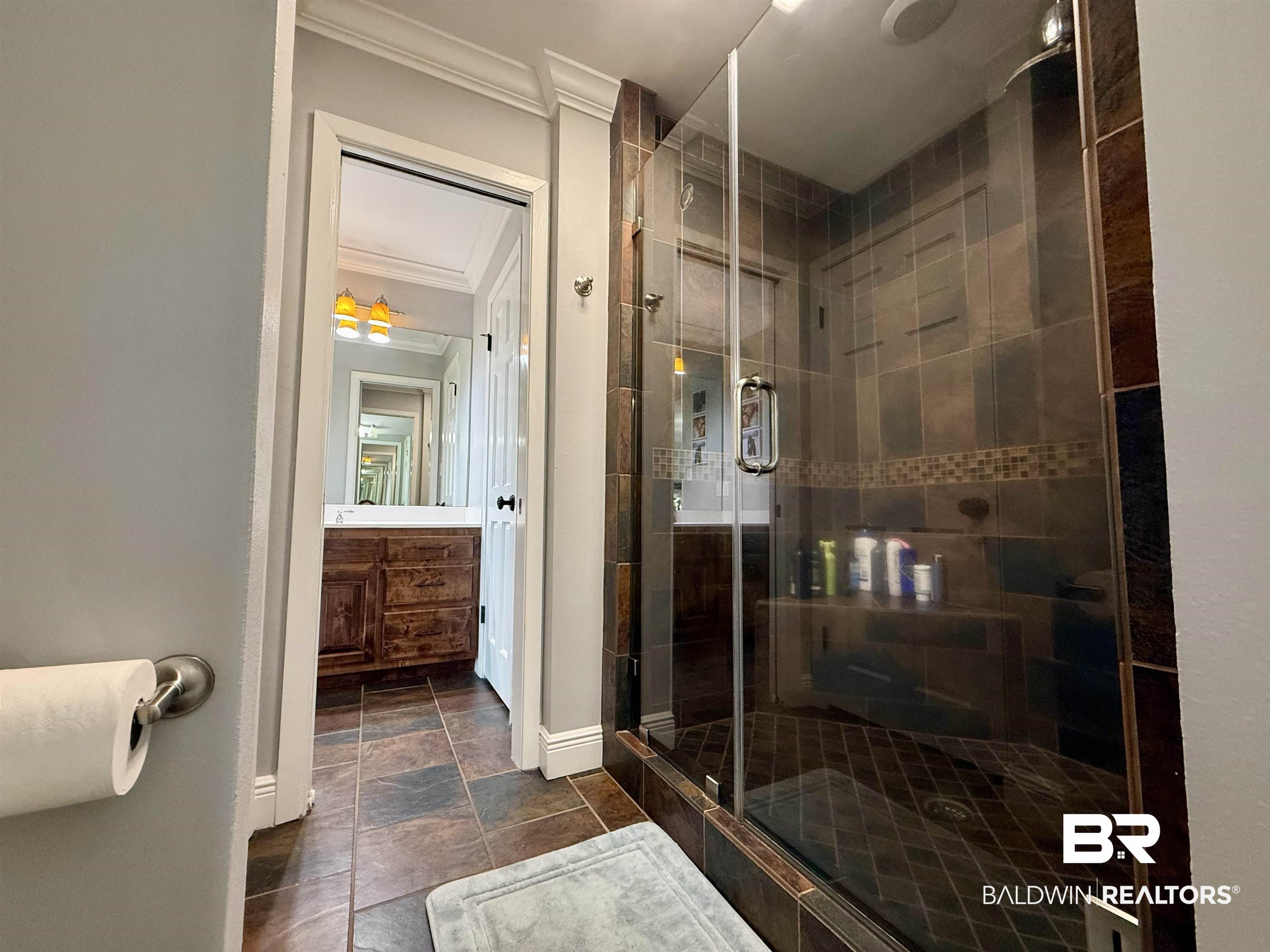 5646 Foshee Road Brewton, AL 36426 - Photo 17 of 37 Bathroom featuring crown molding, a stall shower, vanity, and dark stone finish floors