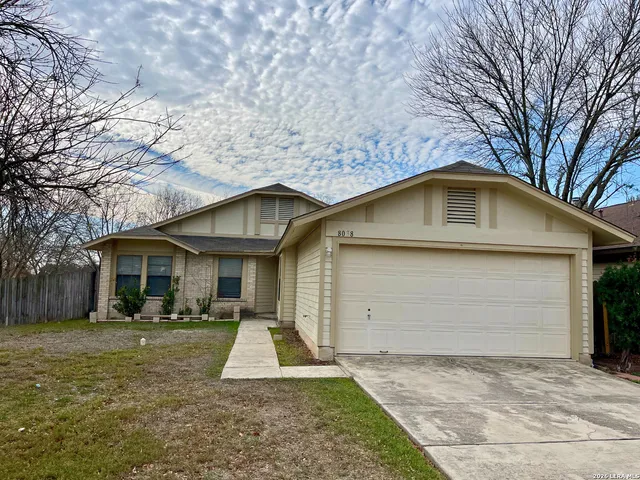 a front view of house with yard garage and green space