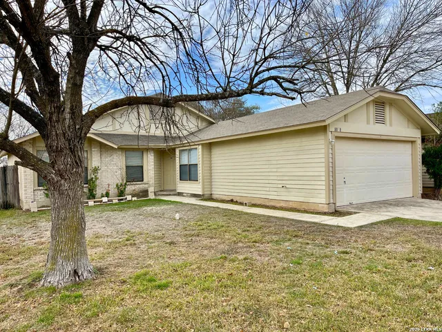 a view of a house with a backyard and garage