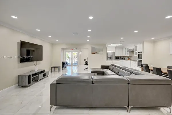 a living room with furniture and a wooden floor